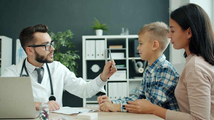 Criança em consulta com pediatra acompanhada da mãe