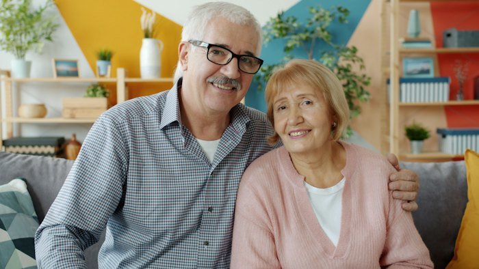 Casal de idosos sorrindo em casa